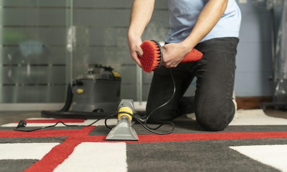 Unrecognizable laundry personnel cleaning carpet with special equipment